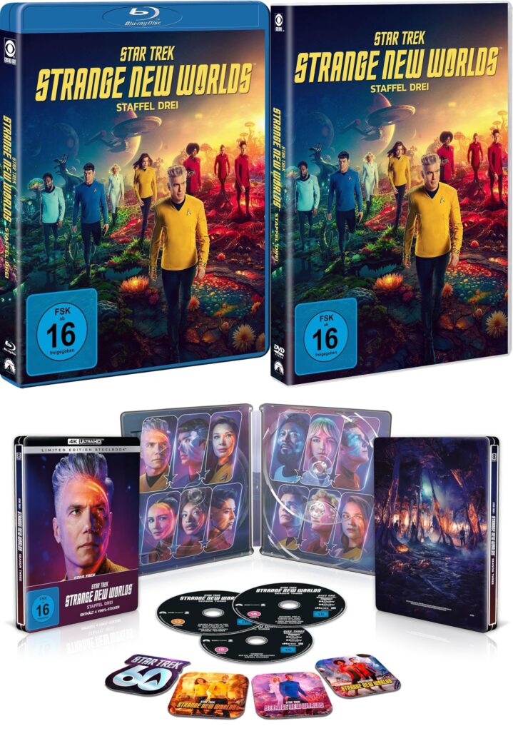 Werbebild für die physische Home Entertainment-Veröffentlichung von Star Trek: Strange New Worlds – Staffel Drei. Oben sind eine Blu-ray-Hülle und eine DVD-Hülle zu sehen, beide mit identischem Covermotiv: Die Crew der Enterprise in farbigen Uniformen (gelb, blau, rot) schreitet durch eine leuchtend bunte, fremdartige Alien-Landschaft mit Pflanzen, Felsen und Raumschiff im Hintergrund. Auf den Covern befindet sich ein Altersfreigabe-Symbol „FSK ab 16“.
Darunter ist eine geöffnete Limited-Edition-Steelbook-Verpackung abgebildet. Auf der Vorderseite ein großes Porträt von Captain Pike, innen mehrere kleine Charakterporträts in grafischen Rahmen. Vor dem Steelbook liegen mehrere beschriftete Discs der Staffel.
Rechts daneben steht ein weiteres Sammler-Steelbook mit einer düsteren Wald-Szene als Artwork. Am unteren Rand liegen zusätzlich Sammler-Extras, drei bedruckte Sticker mit Serienmotiven sowie einer mit Jubiläums-Emblem mit der Zahl 60.